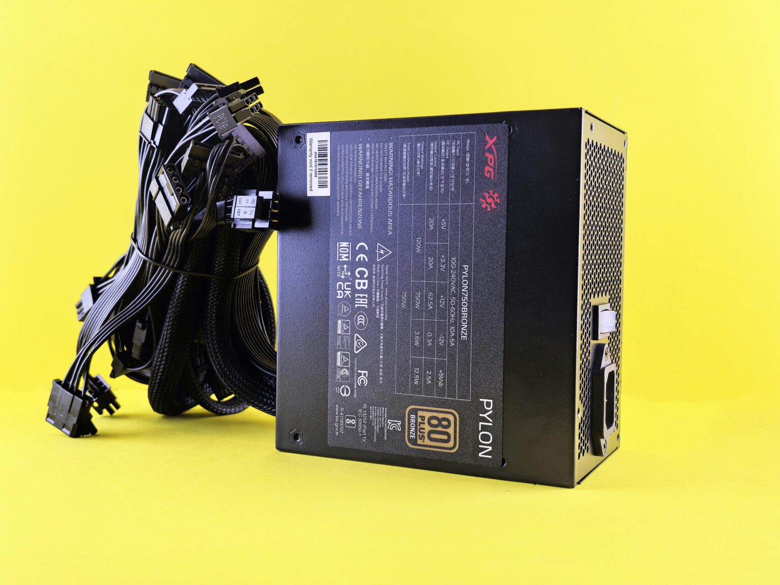 Black PC power supply unit with cables on a vibrant yellow backdrop. Ideal tech image.